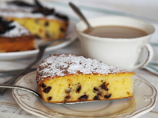Tea with festive or everyday semolina cake and dried plum fruit on a wooden white table. Home cooking for the holiday.
