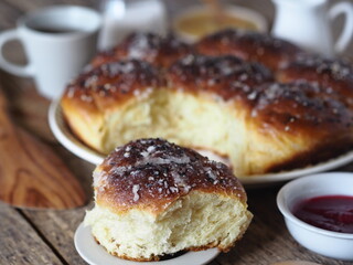 Homemade cake.Buns with jam filling, sprinkled with sesame and icing sugar, on an ancient wooden background, with ingredients and a Cup of tea
