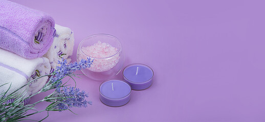 Lavender salt with two candles, decor for bath on purple background. Spa decor