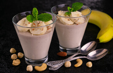 Two glasses with banana mint dessert on a black background.