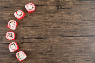 Delicious california sushi rolls placed on wooden surface