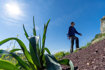 Active young boy wearing sportswear walking in the mountain during sunny day.
