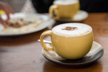 Yellow cappuccino and snacks.