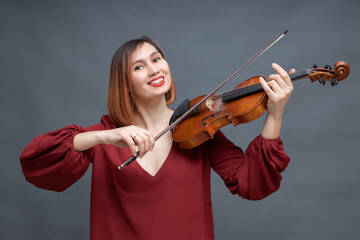 musician playing violin on gray background