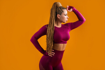 beautiful woman in tracksuit on yellow background 