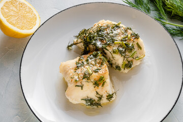Pieces of cod baked with dill and served on a plate.