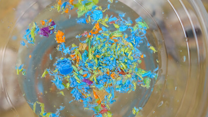 Microplastics in water in a single-use cup. Concept of water pollution and global warming. Climate...