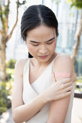 Asian woman being inoculated by getting vaccinated immunity with bandage on her upper arm, concept...