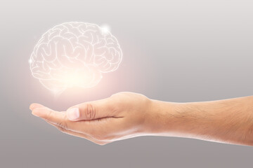 Man holding brain illustration against gray wall background. Concept with mental health protection...