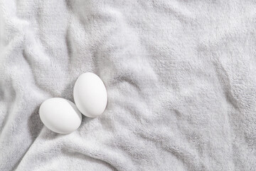 Serenity fur background with two white eggs. Minimal easter at home idea.