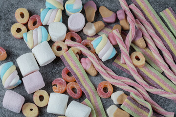 Mix of marshmallow and jellybeans on the marble background - obrazy, fototapety, plakaty