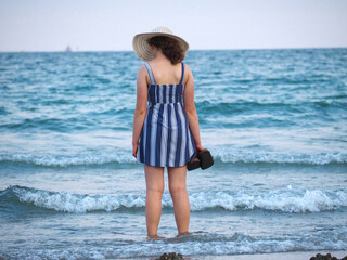 Beautiful woman with a hat at the beach