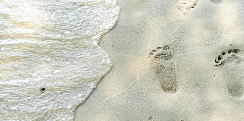traces of feet on the sand. Texture background Footprints of human feet on the sand near the water...