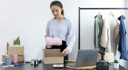Young Asian women pack their clothes into boxes and prepare them to be delivered by post, Online...