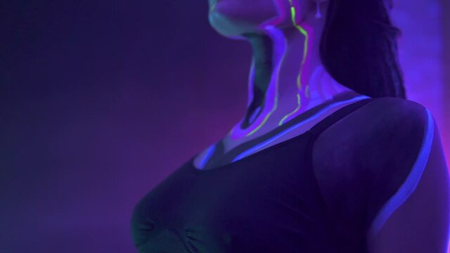 Portrait of a Girl with Dreadlocks in Neon UF Light. Model Girl with Fluorescent Creative Psychedelic MakeUp, Art Design of Female Disco Dancer Model in UV, Colorful Abstract Make-Up. Dancing Lady