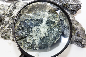 Mineral asbestos viewed through magnifying glass, close-up