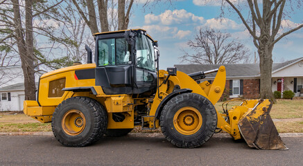 Heavy duty Front End Loader ready to work on Residential Street	