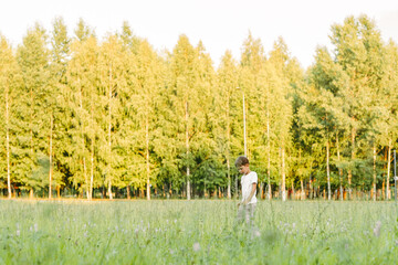 boy runs across the green field. Happy child running on the street. Summer photography
