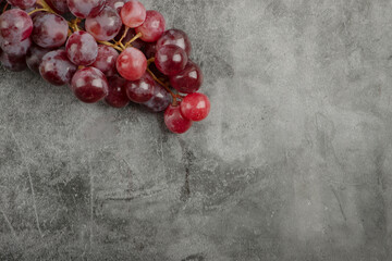 Cluster of red fresh ripe grapes on marble surface