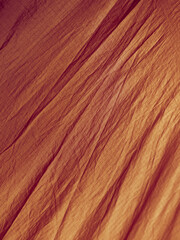 Naklejka premium Orange abstract wrinkled fabric background with copy space, view from above