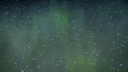 rain falling on green lake