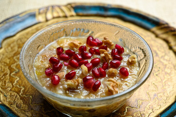 Ashure or Noah's pudding, the turkish dessert porridge in glass bowl on golden dish