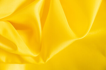 yellow silk crumpled fabric as background close-up
