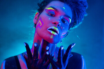 Cocky Girl with Dreadlocks in Ultraviolet neon light with Foggy Background. Bodyart