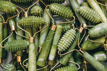 Many massage rollers made of green jade stone. Top view. Copy, empty space for text