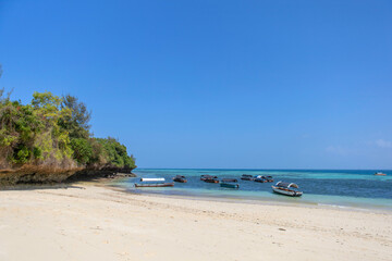 Indian Ocean coast in Zanzibar. Sunny day in a tropical location with boats. Turtle Island or Prison Island in Tanzania.
