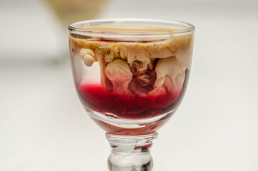 Interesting drink shot based on cream, liqueur and grenadine called Brain Hemorrhage prepared for Halloween party