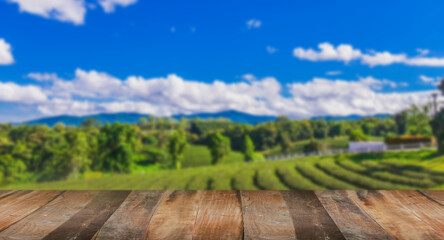 The empty wooden table is ready. Green tea garden on blurred background.