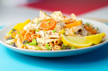 Piri piri style chicken on a bed of wholewheat pasta and vegetables, with a cool sour cream and chive dressing