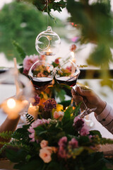 Toast In Restaurant With Full Glasses Of Red Wine. date, romance, candles, flowers