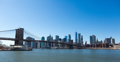 Naklejka na ściany i meble View of Brooklyn Bridge and Manhattan skyline WTC Freedom Tower from Dumbo, Brooklyn. Brooklyn Bridge is one of the oldest suspension bridges in the USA