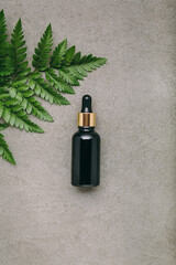 Transparent cosmetic glass dropper bottles on stone background.