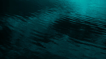 Dark blue green abstract background. Reflection of light on a smooth surface of water with small...