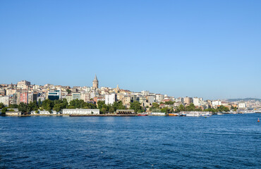 Fototapeta na wymiar Scenic view with one of the symbolism of old Istanbul, Galata Tower at skyline from the seaside, landscape of Golden Horn, Turkey