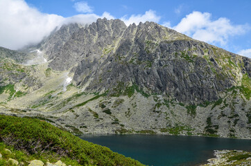 Fototapeta na wymiar Beautiful mountain lake Batizovske Pleso, surrounding peaks and the highest peak of High Tatras mountains, Gerlachovsky stit. Slovakia