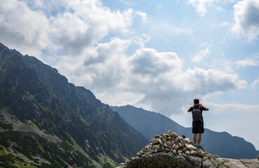 Man photographer with backpack taking photographs with smartphone camera in a mountains. Travel and active lifestyle concept. High Tatras, Slovakia