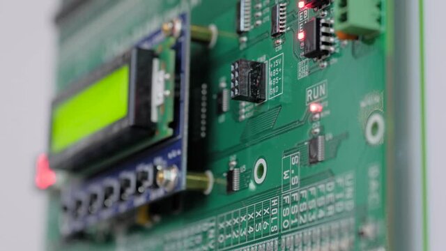 Green printed circuit board - pcb for elevator with digital display module at lift exhibition, trade show - close up view. Technology and electronic concept
