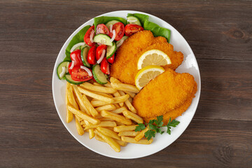 smażone filety z kurczaka, frytki i pomidory z ogórkiem © robert6666