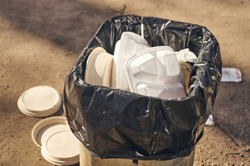 Disposable food container in  garbage bin.  Overflowing garbage bin. Environmental pollution.