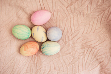 Beautiful watercolor paints on Easter eggs that lie on a delicate pink fabric. Easter concept.
