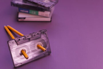 Man rewinds and winds cassette tape with pencil in retro way with nostalgia.