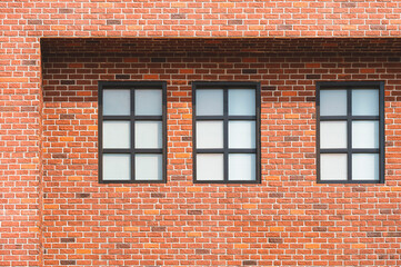Three frosted glass windows on brick wall of vintage house building