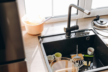 Pile of dirty dishes in the metal sink.