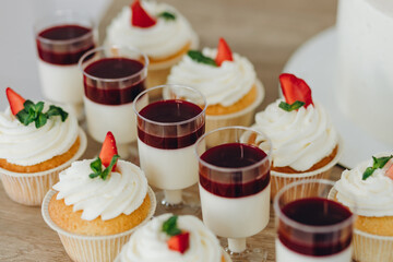 Top view of selection of colorful and delicious cake desserts on the table on light kitchen.
