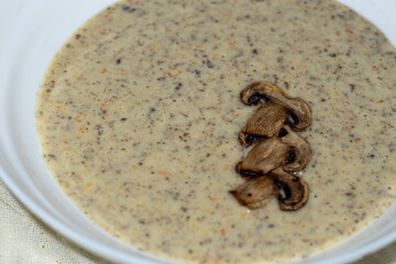 Aromatic mushroom cream soup with champignons. Fresh vegetables and freshly baked bread. A hearty and delicious lunch.