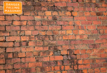 Danger Falling Masonry sign on a old red brick building